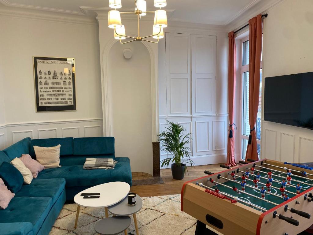 - un salon avec un canapé bleu et un ballon de foot dans l'établissement Beautiful double apt family babyfoot 2 parking, à Nancy