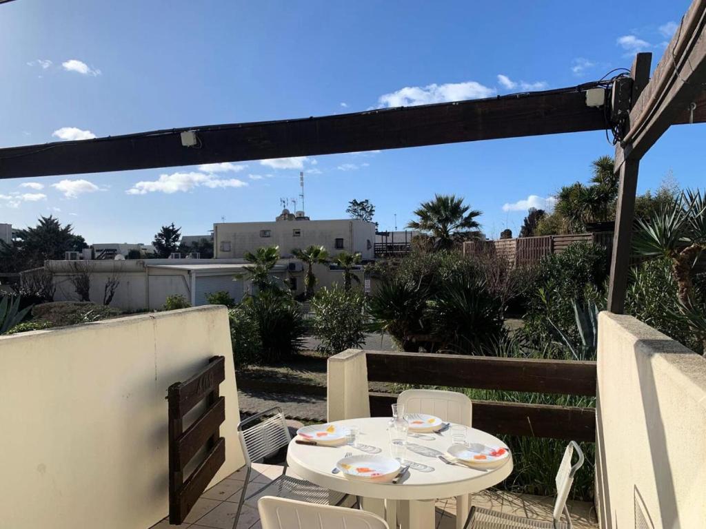 une table blanche et des chaises sur une terrasse dans l'établissement Résidence Port Nature Colline 4 - Studio 2 pers. - Port Nature Colline 4 MAE-6144, au Cap d'Agde