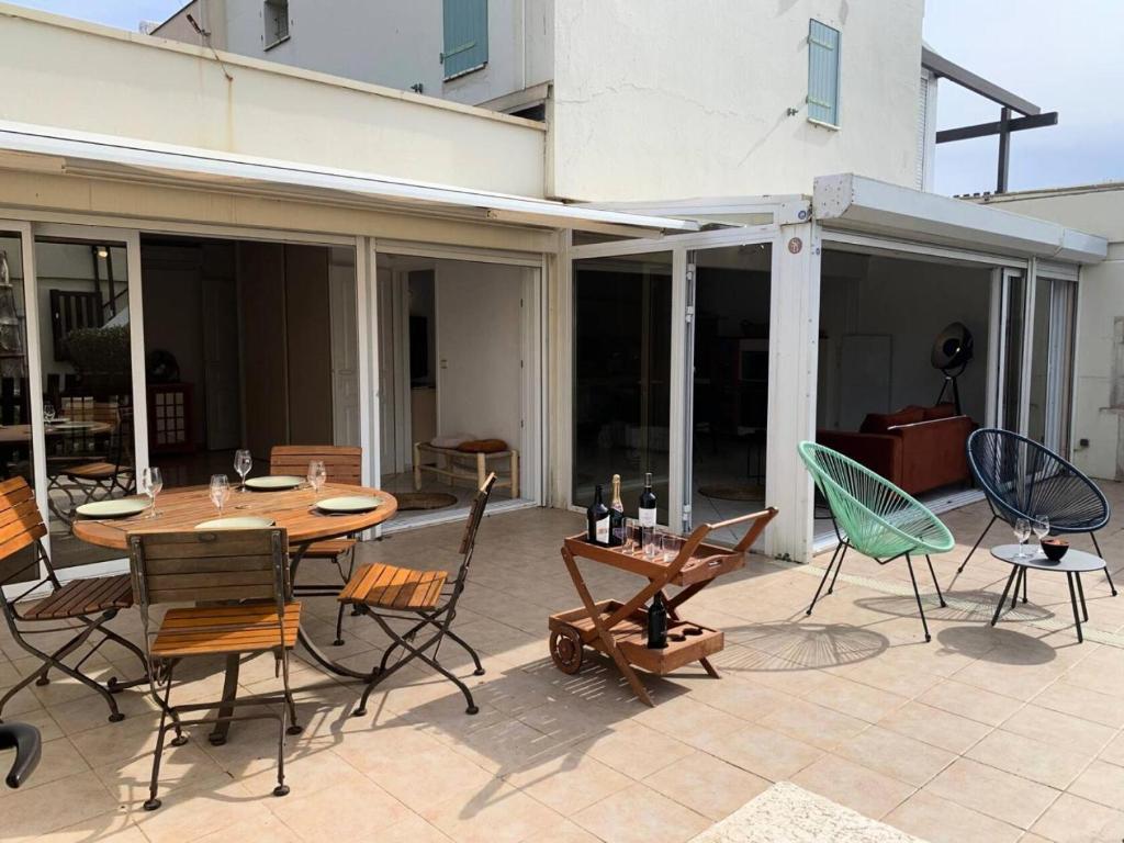 un patio avec une table et des chaises en bois dans l'établissement Résidence Port Nature Village 2 - Grande villa 6 Pers. Port Nature Village MAE-5501, au Cap d'Agde