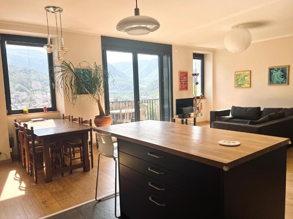 a kitchen and living room with a large island at Le balcon du boulevard bellevue in Saint-Claude