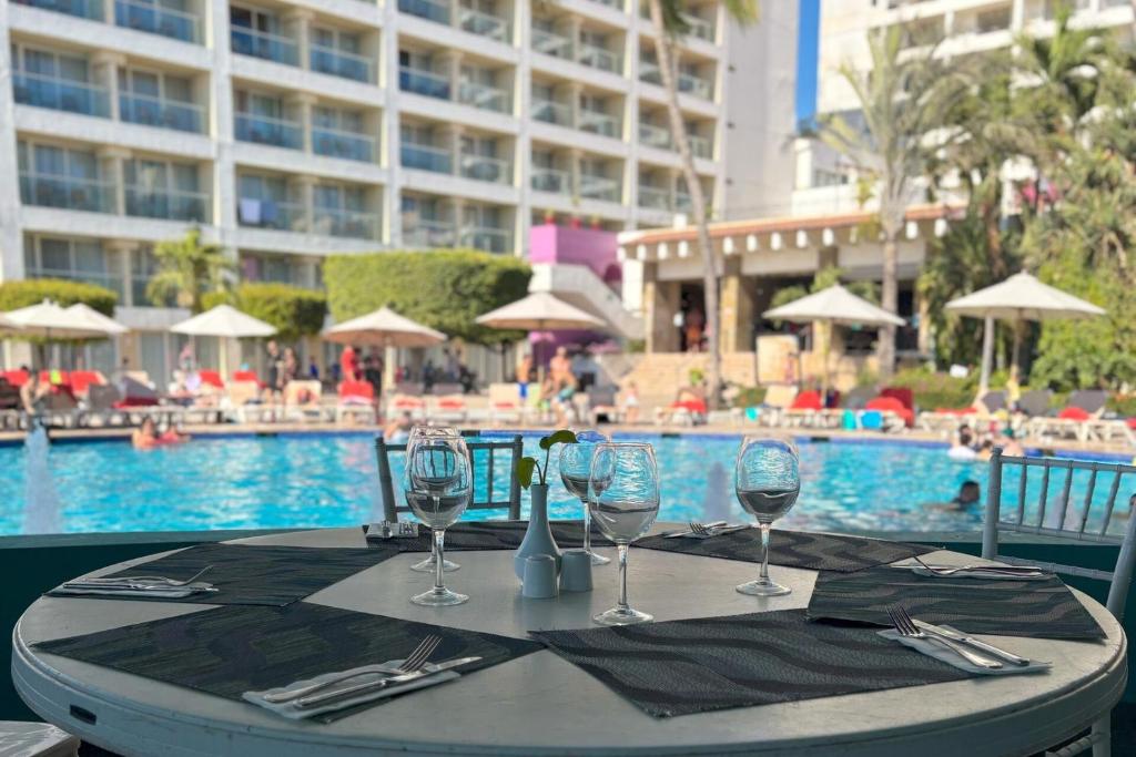 een tafel met wijnglazen op een tafel bij een zwembad bij Beach and Pool Access! in Puerto Vallarta