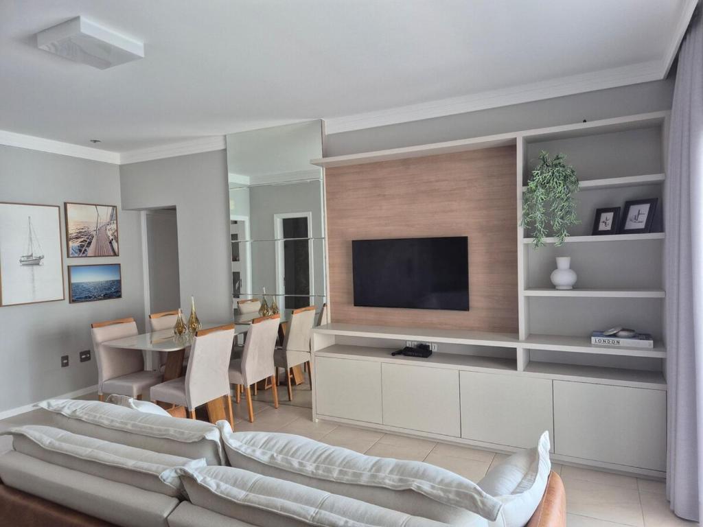 a living room with a couch and a television at Apartamento moderno e funcional bem localizado in Balneário Camboriú