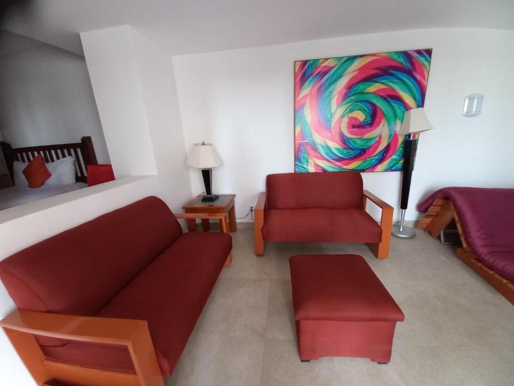 a living room with a couch and a chair at Spacious, standard with beach access & wifi! in Puerto Vallarta
