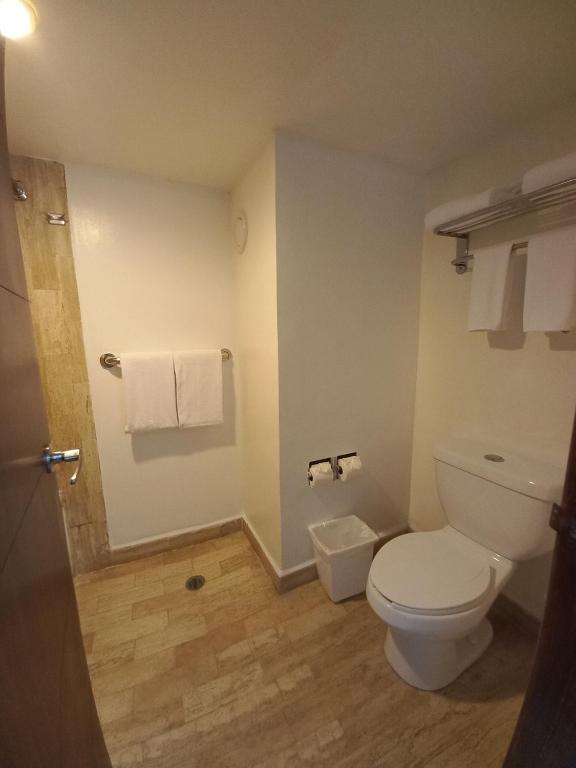 a bathroom with a toilet and towels on the wall at Spacious, comfortable, and with beach access! in Puerto Vallarta