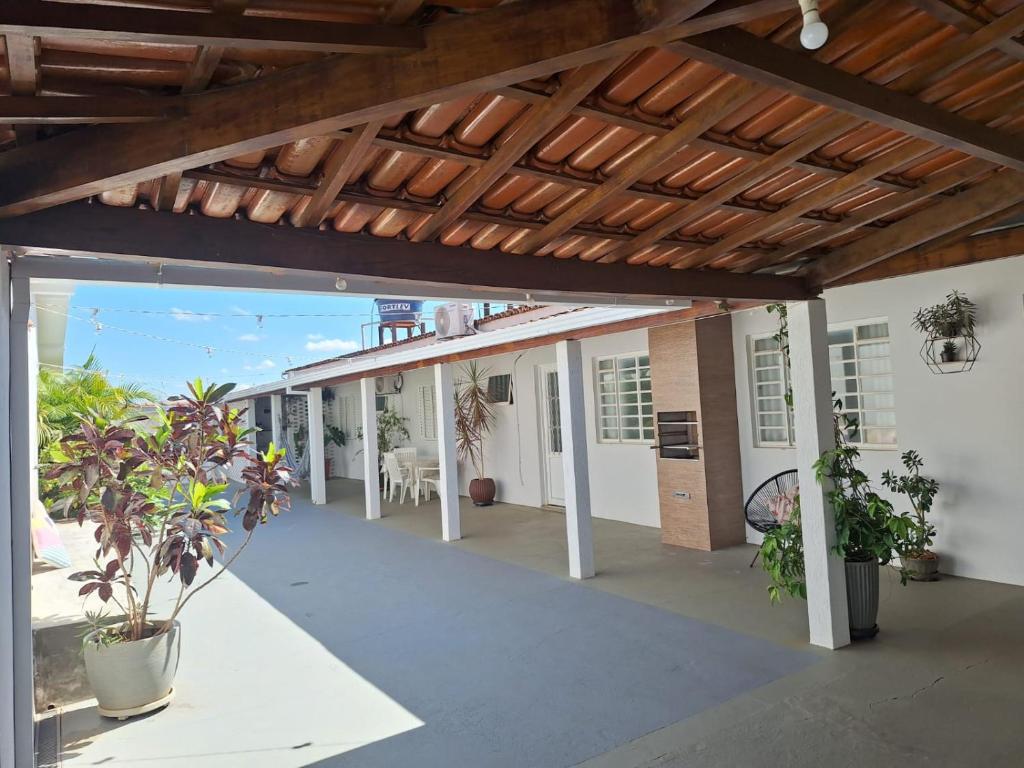 an outdoor patio with a wooden ceiling and plants at Casa aconchegante em Guapé, Lago de Furnas. in Guapé