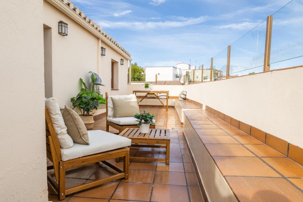a balcony with chairs and tables on a building at Apartamentos Canterías in Cáceres