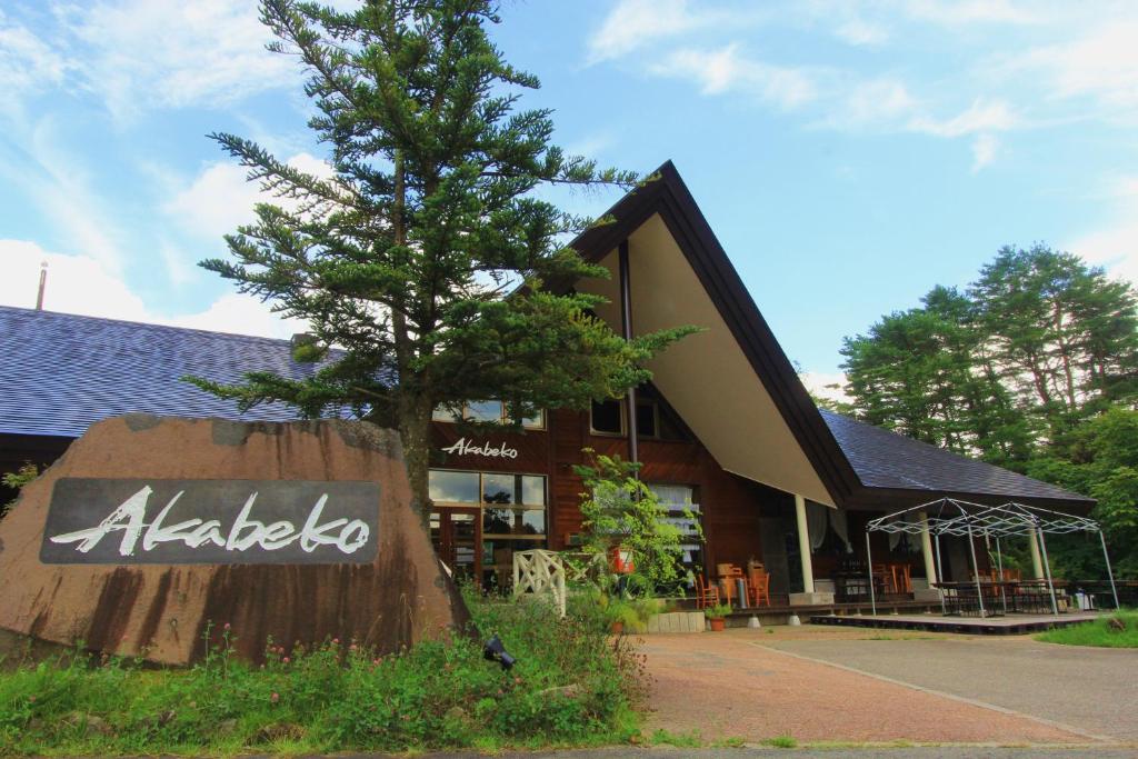 a store with a tree in front of a building at Nature Cottage Akabeko in Kitashiobara