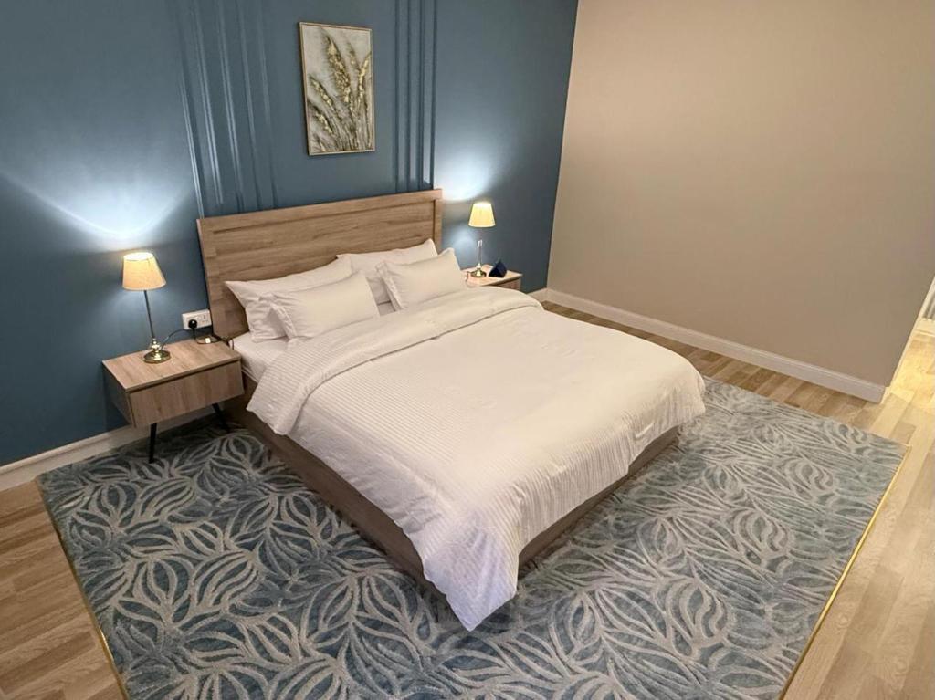 a bedroom with a large bed and a rug at شقق السماح الفاخرة in Taif