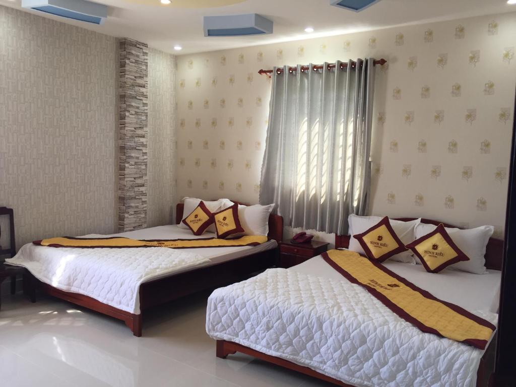 een slaapkamer met 2 bedden en een raam bij Minh Kieu 2 Hotel in My Tho