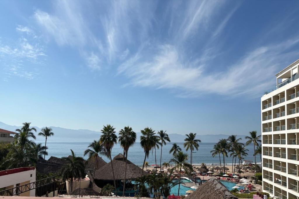 Una vista de un resort con palmeras y el océano. en Spacious with exclusive beach access & WiFi!, en Puerto Vallarta