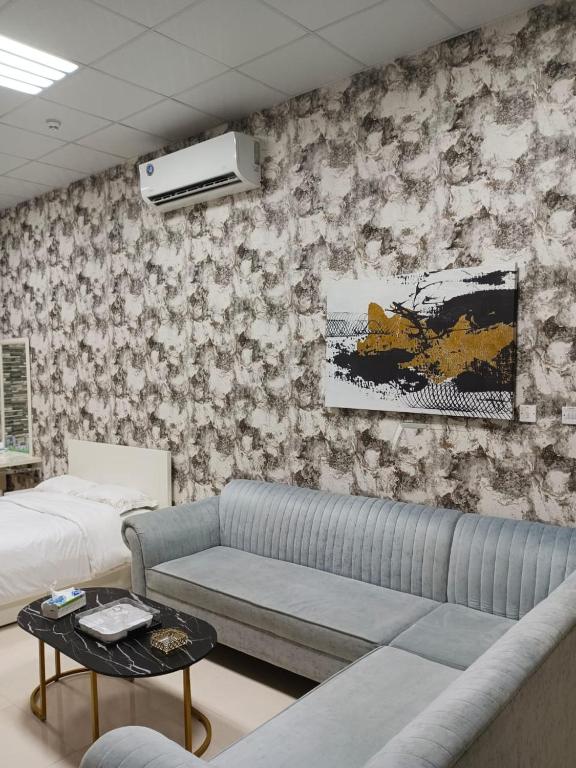 a living room with a couch and a bed at Fully Furnished Studio Apartment in Smart Umm Al Quwain in Umm Al Quwain