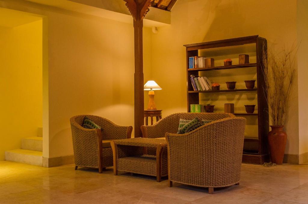 a room with two chairs and a table and a book shelf at Sapodilla Ubud in Ubud