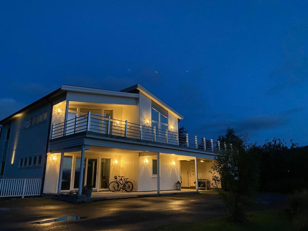 a large house with a balcony at night at Villa Gratangen in Gratangen