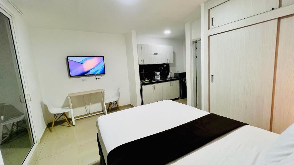 Una habitación blanca con una cama y una cocina. en 402 studio apartment in El Peñon, en Cali