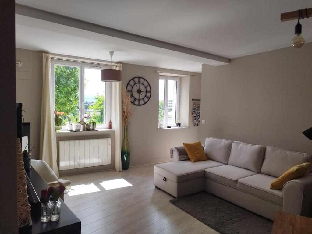 - un salon avec un canapé blanc et une fenêtre dans l'établissement Charmant appartement Le Coteau - Roanne, à Le Coteau
