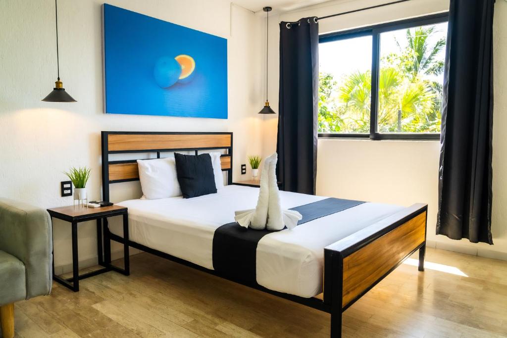une chambre avec un lit et une grande fenêtre dans l'établissement Casa Maca, à Playa del Carmen