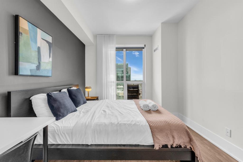 トロントにあるDowntown west Suitesのベッドと窓のある寝室