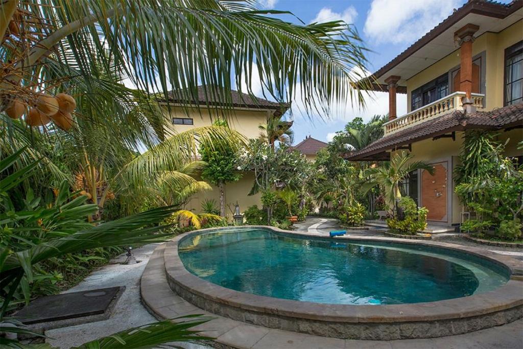 a swimming pool in front of a house at Villa Chandra in Seminyak
