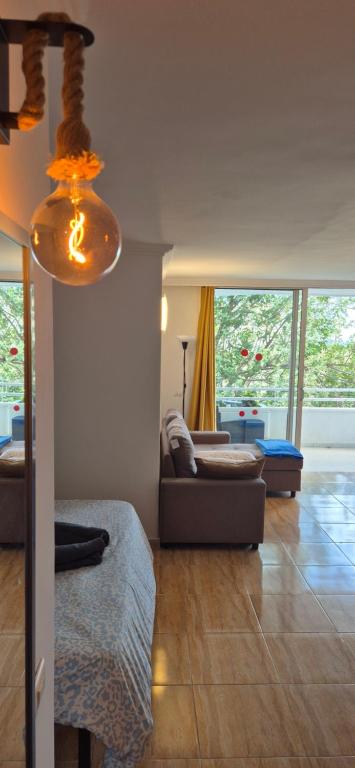 een woonkamer met een bank en een lamp bij Relax flat palm view in San Miguel de Abona