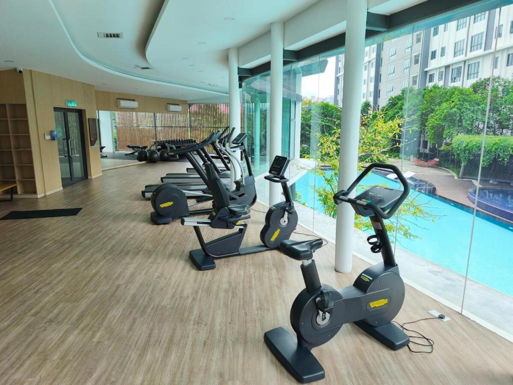 una fila di cyclette in una palestra con piscina di Cozy HomeBit a Kuala Lumpur
