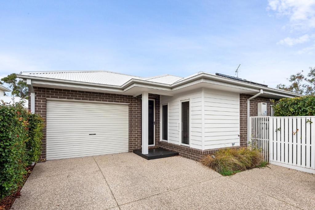 a brick house with a white garage at Latte's Nest in Point Lonsdale