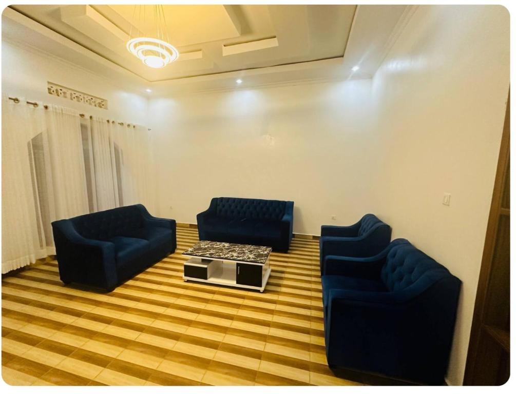 a meeting room with two blue chairs and a table at Brand new house in Kigali