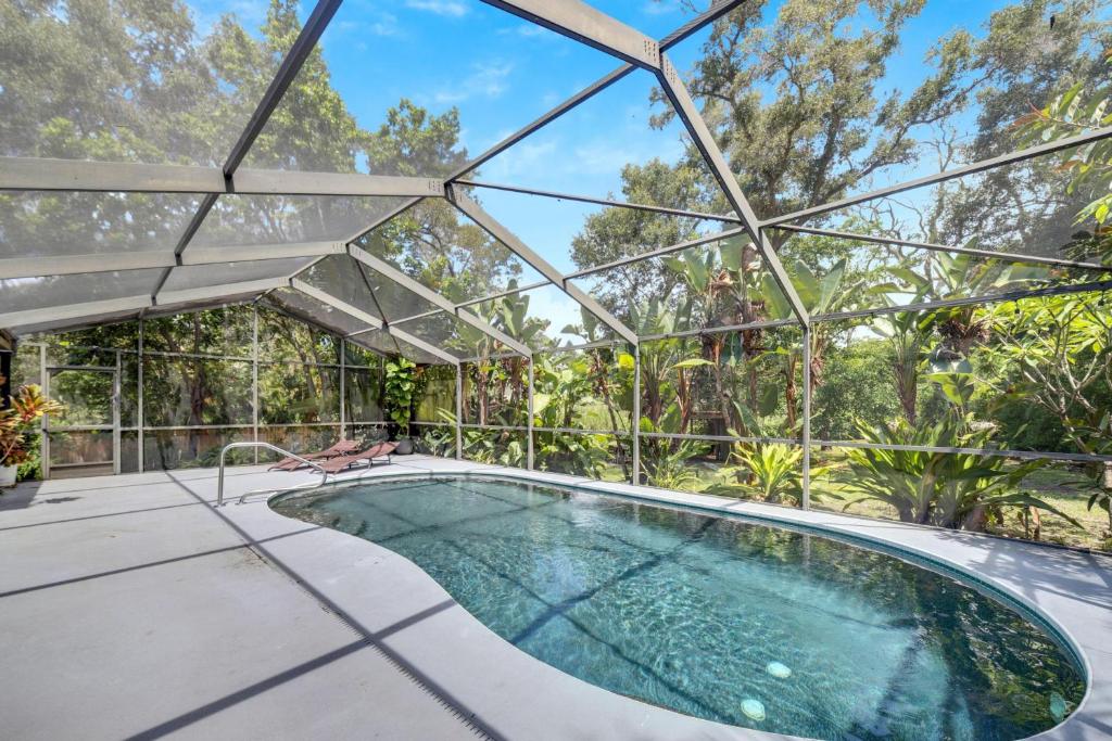 een binnenzwembad in een glazen huis met een patio bij 1331 Normandy Cir in Palm Harbor