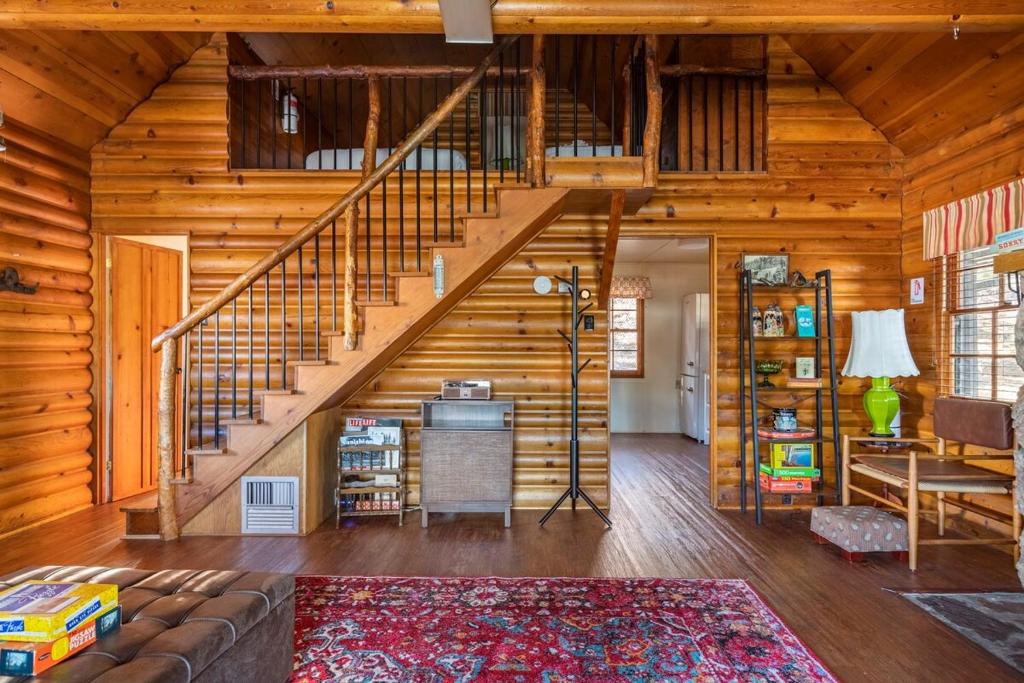 a living room with a staircase in a wooden house at Chair 9 Chalet in Big Bear Lake