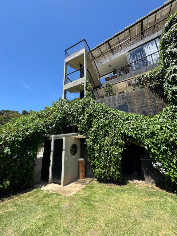 an ivy covered building with a door and a window at Mirante de itaipava in Itaipava