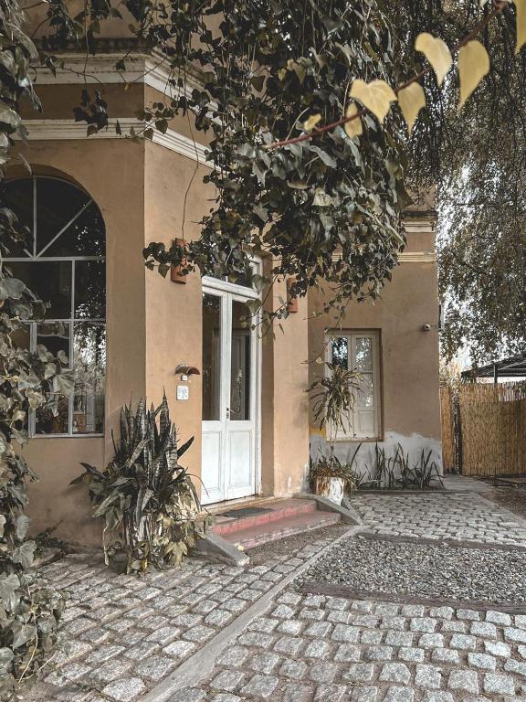 a house with a white door and some plants at Posada Niña Juana in Villa Dolores