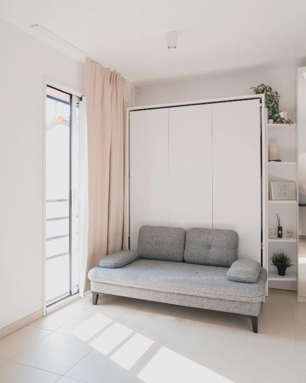 - un canapé dans une chambre avec une grande fenêtre dans l'établissement Nice Colors à coté de la plage, de la promenade des anglais et de la gare, à Nice