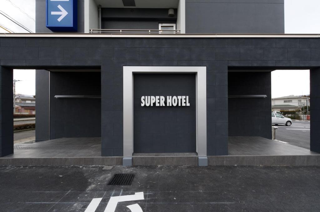 ein Gebäude mit einem Schild, das Super-Hotel liest in der Unterkunft Super Hotel Gotemba Nigo-Kan in Gotemba