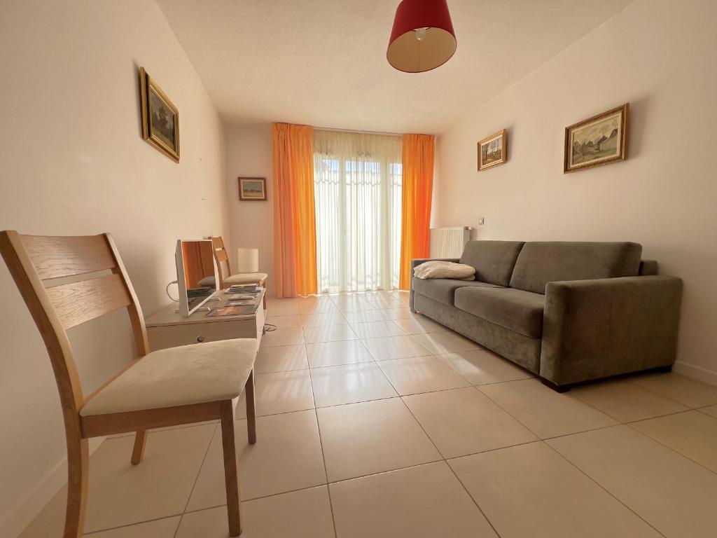 un salon avec un canapé et une chaise dans l'établissement Appartement confortable proche centre-ville, 4 pers, parking inclus - FR-1-474-209, à Arcachon