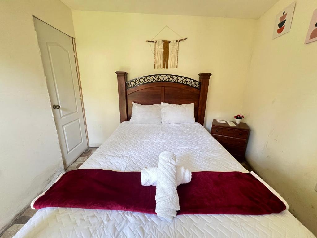 a bedroom with a bed with a stuffed animal on it at Casa del viajero colonial in Antigua Guatemala