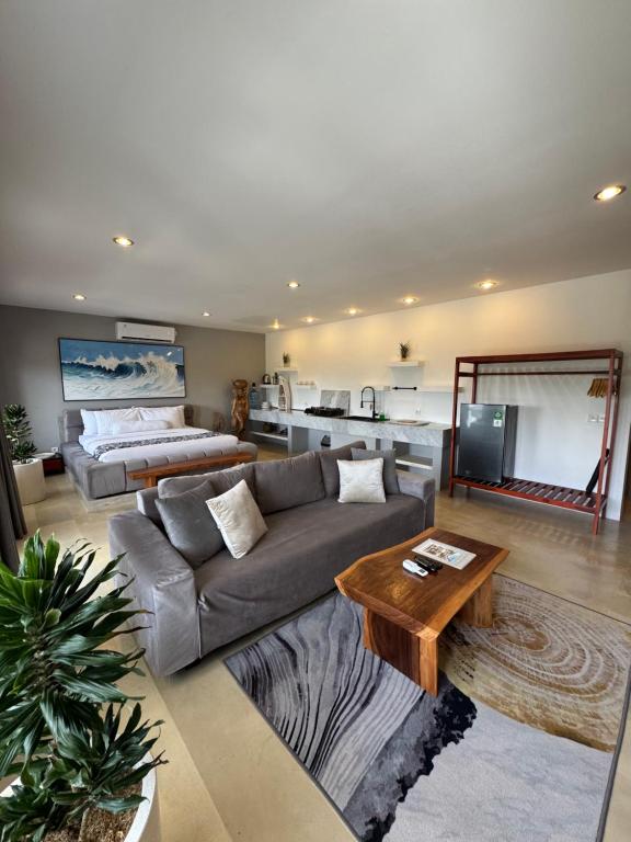 a living room with a couch and a table at Uluwatu Stay's Deluxe Suite #5 in Uluwatu