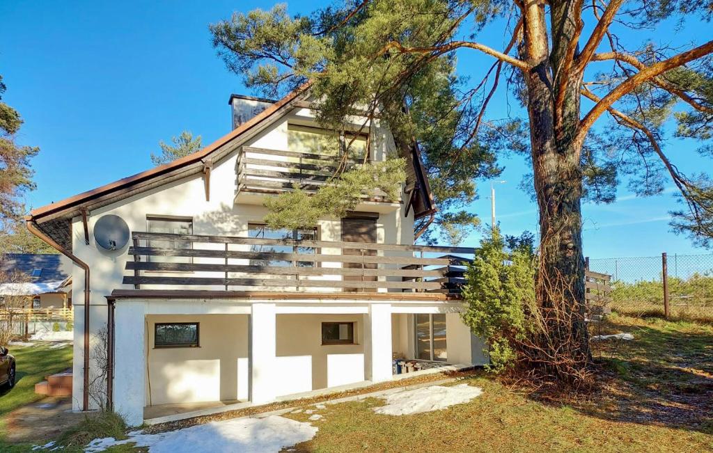 a white house with a tree in front of it at Awesome Home In Stezyca With Wifi in Stężyca