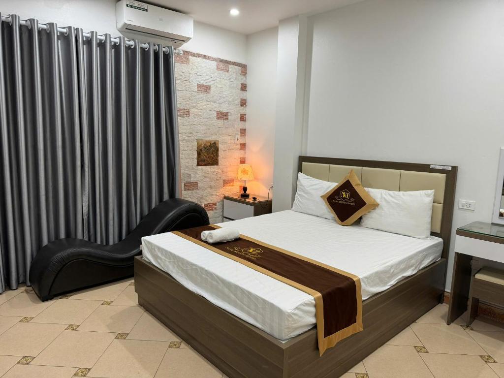 a bedroom with a bed and a chair in it at NH Hotel in Hanoi