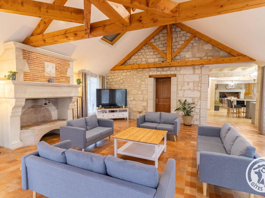 a living room with blue furniture and a fireplace at Séjourner au cœur de la nature entre Tours et Angers - FR-1-622-101 in Saint-Philbert-du-Peuple