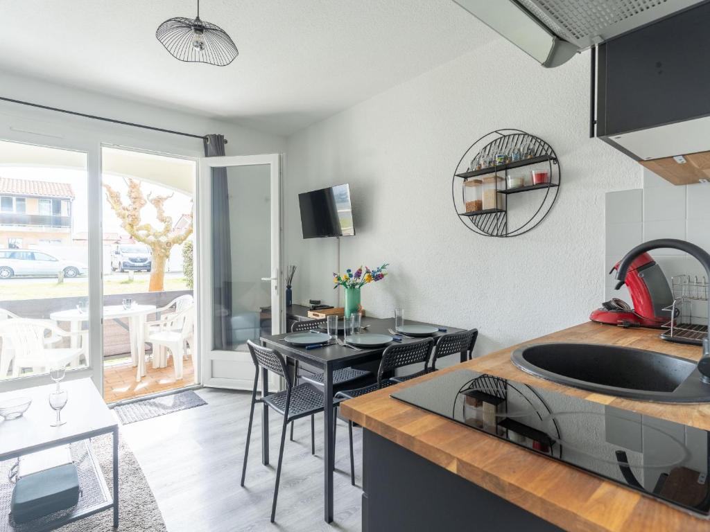 une cuisine avec un évier et une table avec des chaises dans l'établissement Appartement cosy avec terrasse - Biscarrosse Plage - 4 pers - FR-1-319-592, à Biscarrosse
