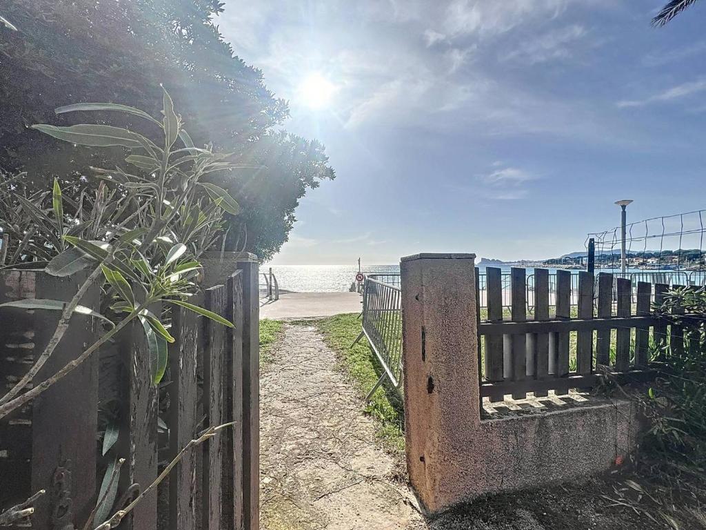 une clôture en bois à côté d'une plage avec un portail dans l'établissement Appartement T3 avec jardin, accès direct plage - FR-1-770-43, à Saint-Cyr-sur-Mer