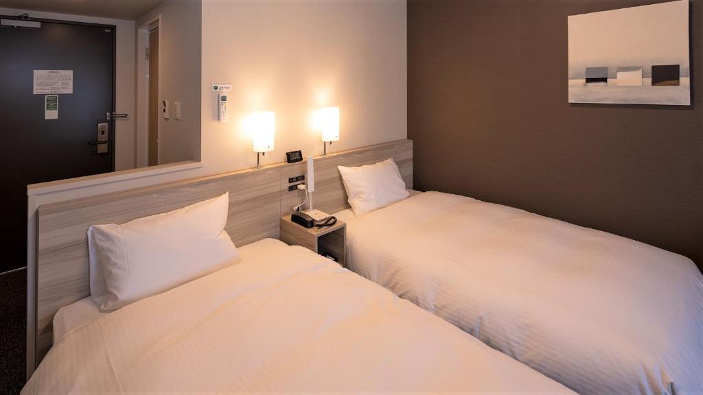 Postel nebo postele na pokoji v ubytování Hotel Route Inn Imizu