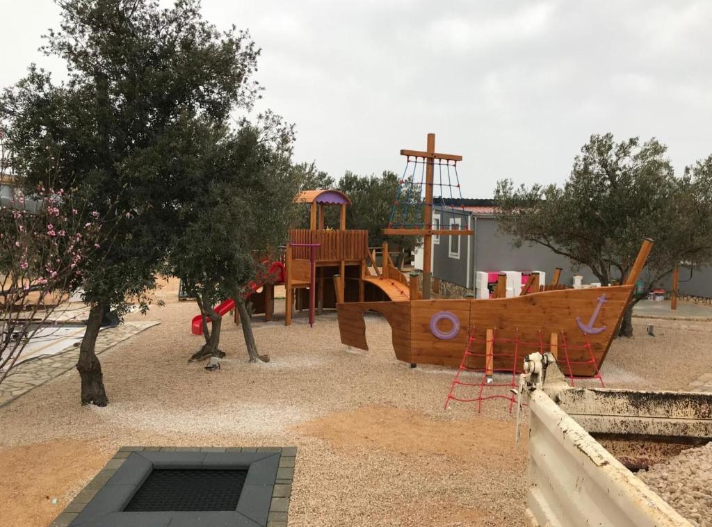 a playground with a wooden boat in a park at Gabrijela House in Pirovac