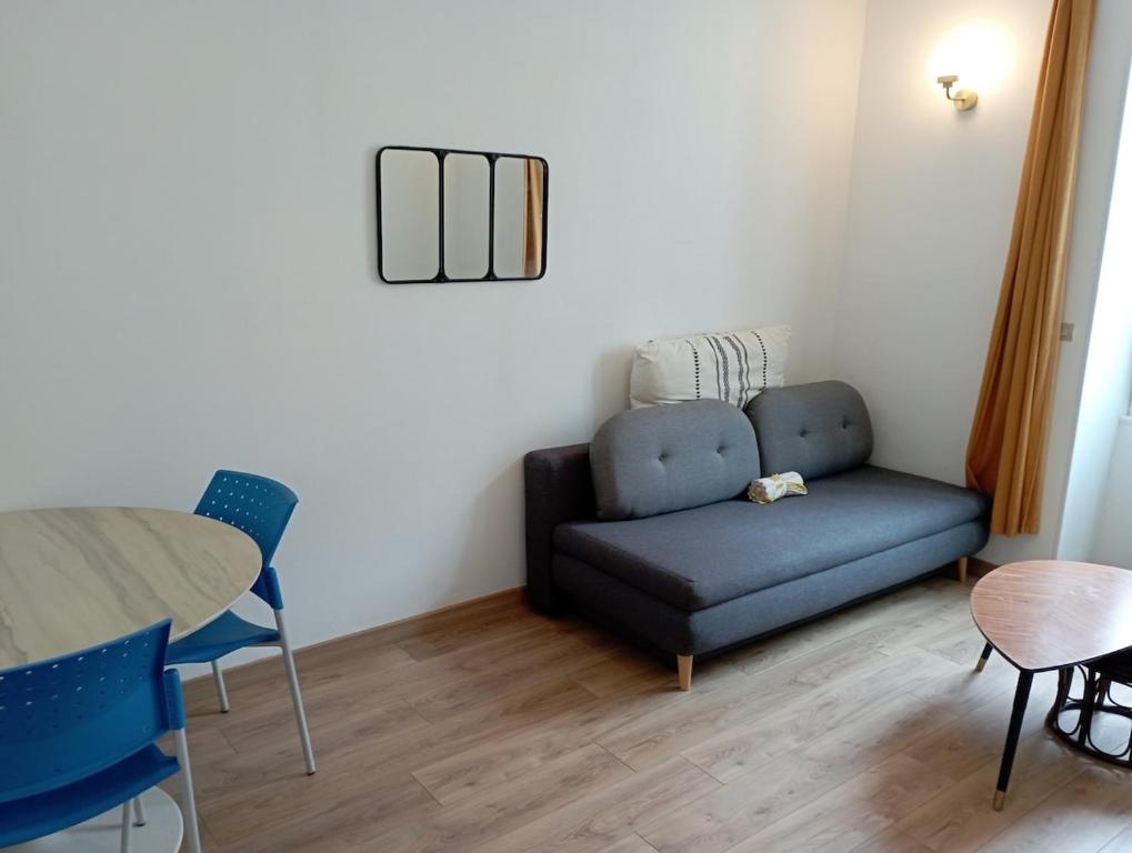 un salon avec un canapé bleu et une table dans l'établissement Appartement 2 pièces rénové, à Nantes