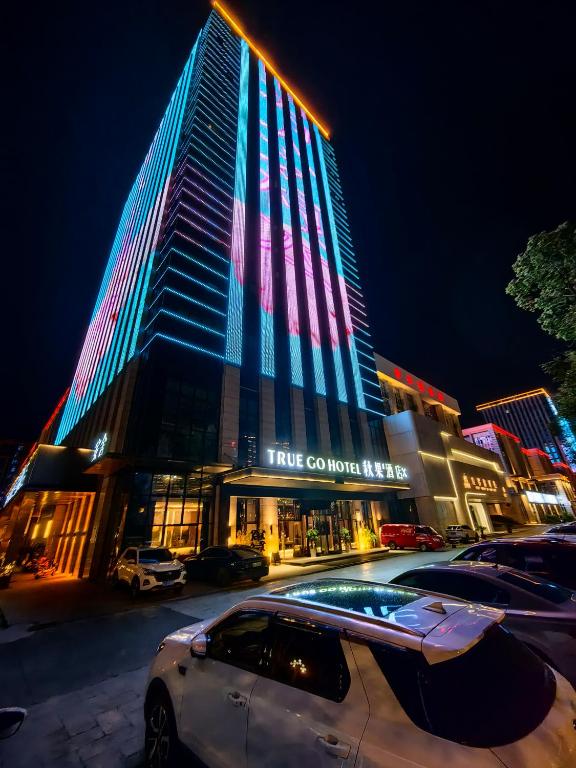 成都TRUE Go hotel的一座高大的建筑,晚上有五颜六色的灯光