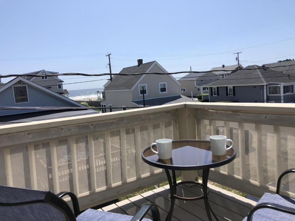 a balcony with a table and chairs on a fence at Seascapes W153 Fantastic condo steps away from Wells Beach and town center 1900 in Wells