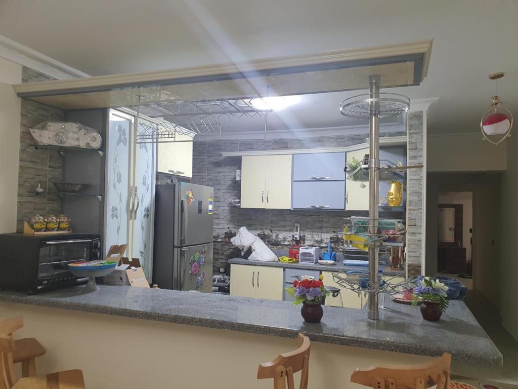 a kitchen with white cabinets and a counter top at شقة روعة المقطم in Cairo