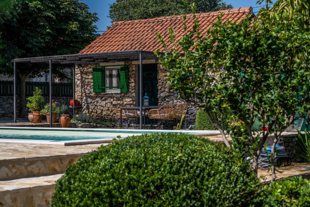 a house with a swimming pool in front of it at Kalpic Suites & Villa in Lozovac