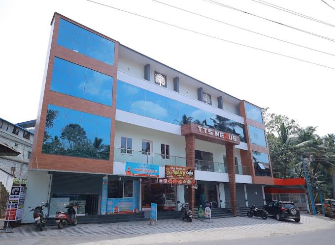 a large building with motorcycles parked in front of it at TTS Residency in Kaliyal