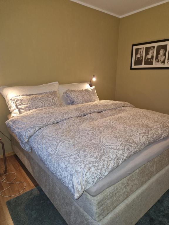 a bedroom with a bed with white sheets and pillows at Leilighet i nærheten av Telegrafbukta in Tromsø