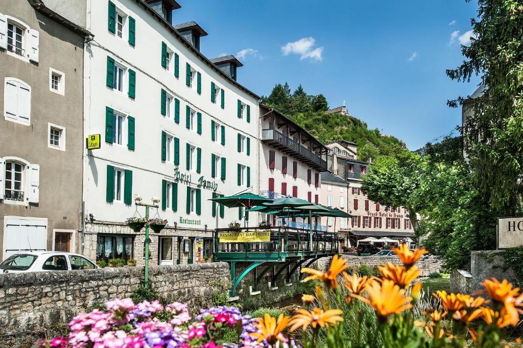 eine Gruppe von Gebäuden und Blumen in einer Stadt in der Unterkunft Logis Hotel Restaurant Family & Spa in Meyrueis